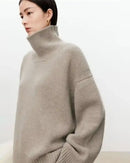 Woman styling an oversized cashmere turtleneck, ultra-soft Mongolian fibers and roomy silhouette pair with leggings or leather pants for elevated WFH comfort.